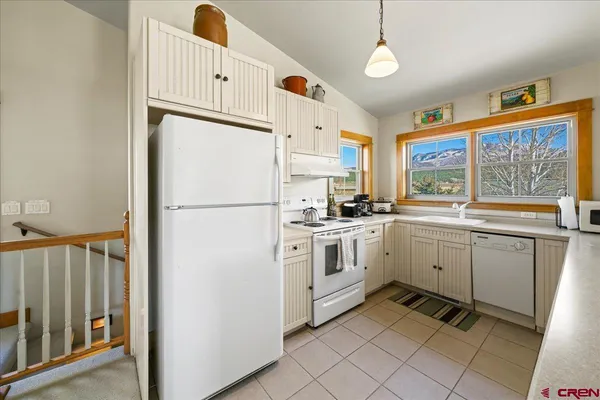 a kitchen with white cabinets and white appliances