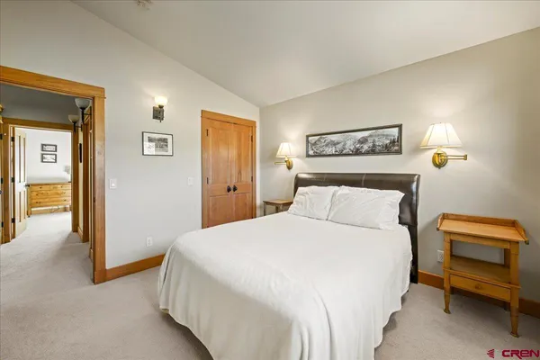 a bedroom with a bed and painting on the wall