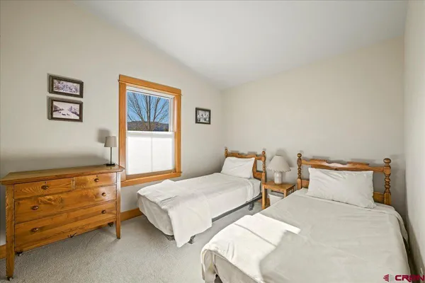a bedroom with two beds and painting on the wall