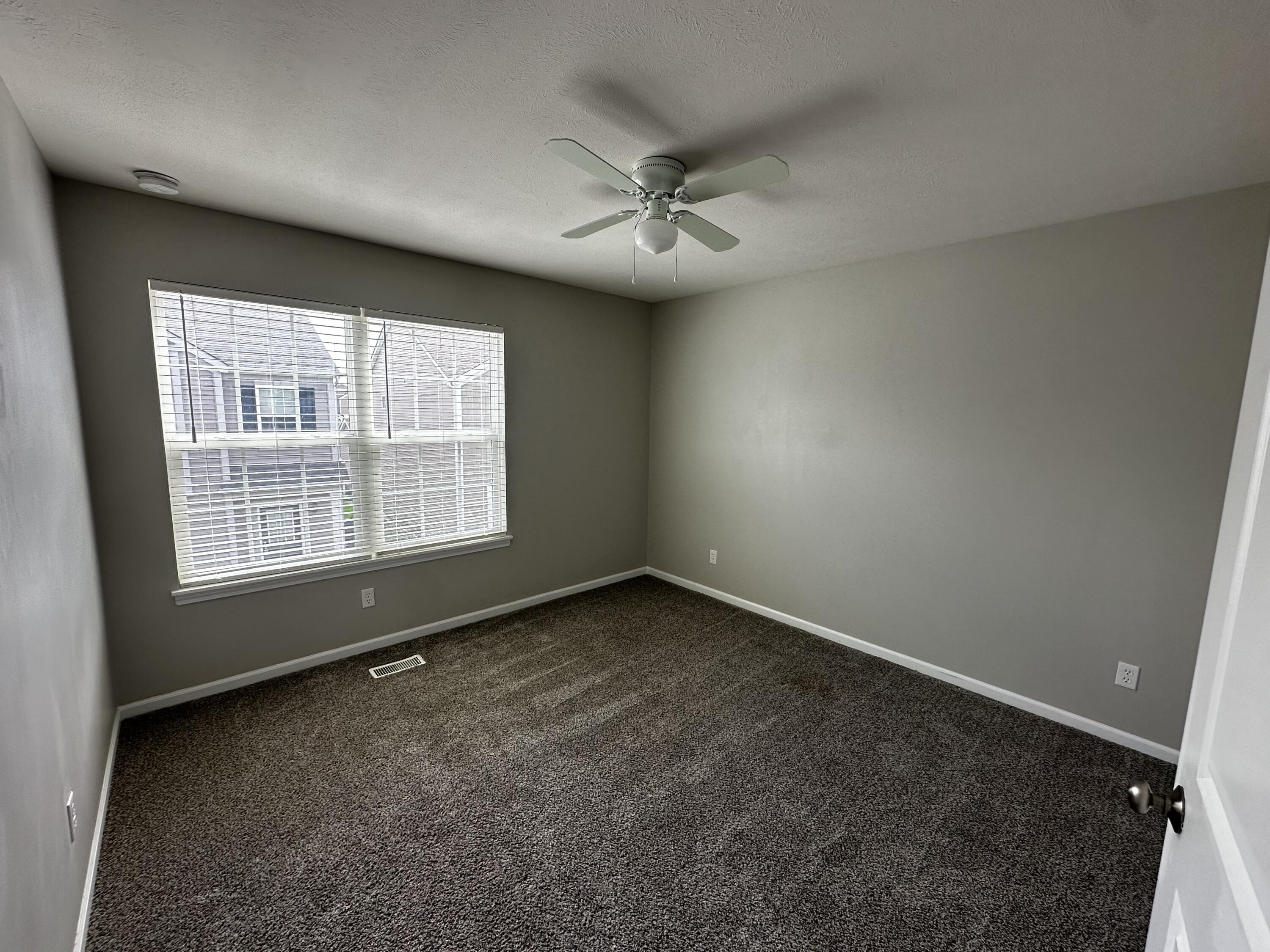 1077 East 115th Lane Crown Point, IN 46307 - Photo 13 of 16 an empty room with windows and ceiling fan