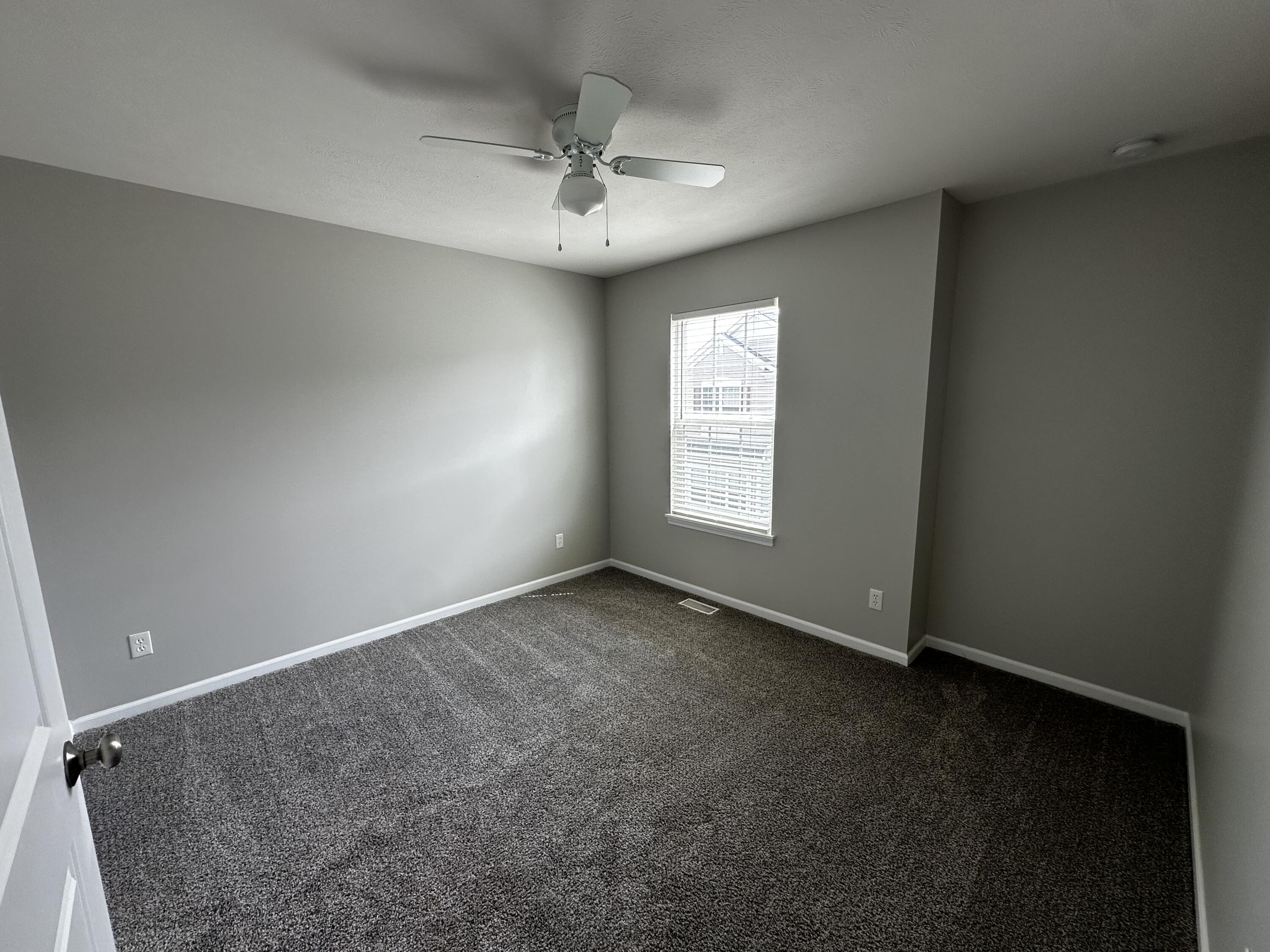 1077 East 115th Lane Crown Point, IN 46307 - Photo 14 of 16 an empty room with windows and chandelier fan