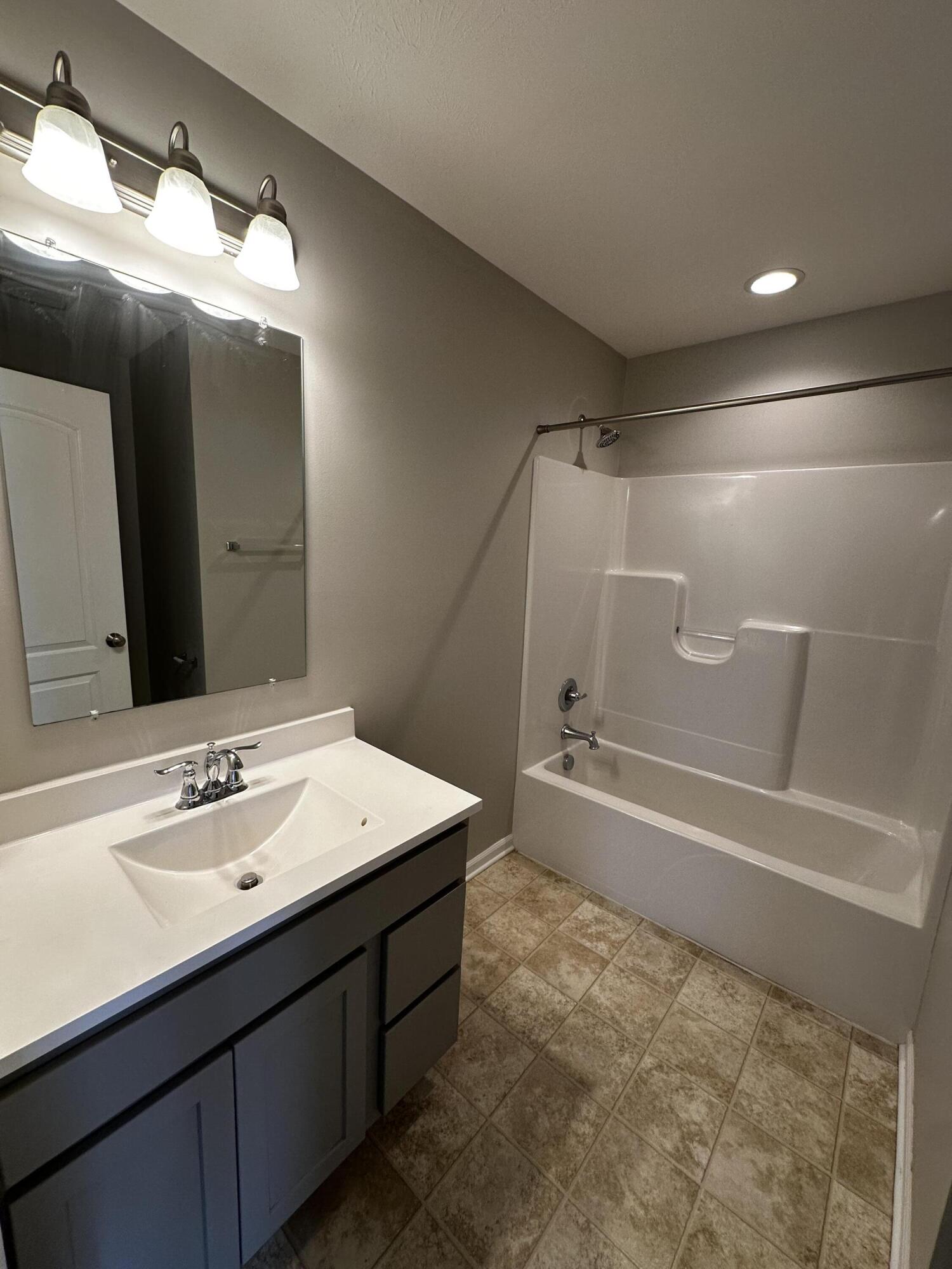 1077 East 115th Lane Crown Point, IN 46307 - Photo 8 of 16 a bathroom with a sink mirror and a bathtub