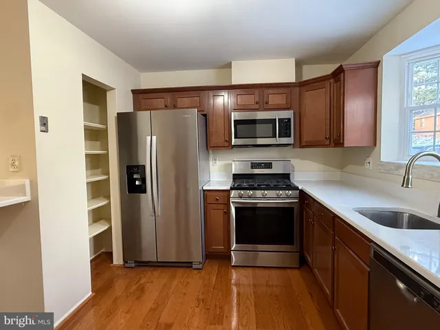 a kitchen with granite countertop a refrigerator and a sink