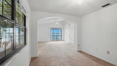 a view of an empty room with closet and a window