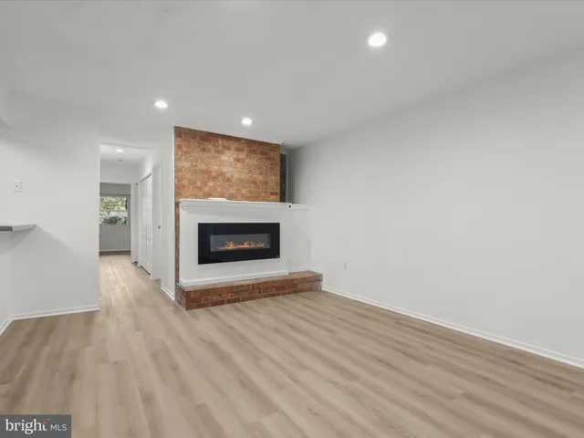 a view of empty room with wooden floor and fireplace