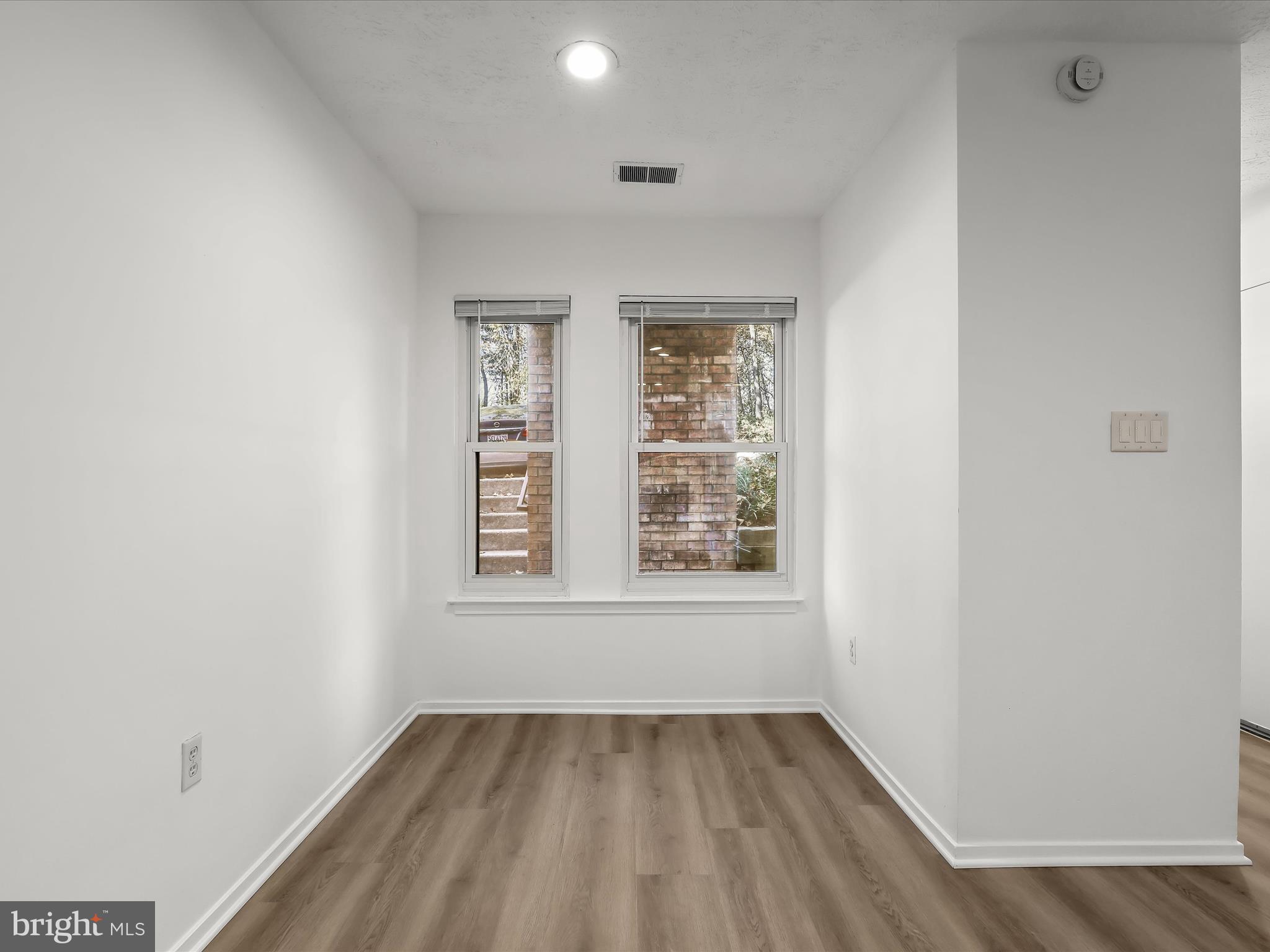 7517 Weather Worn Way, Unit A Columbia, MD 21046 - Photo 13 of 27 an empty room with wooden floor and windows