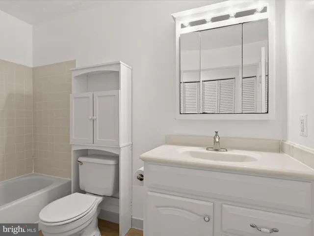 a bathroom with a sink toilet vanity and tub