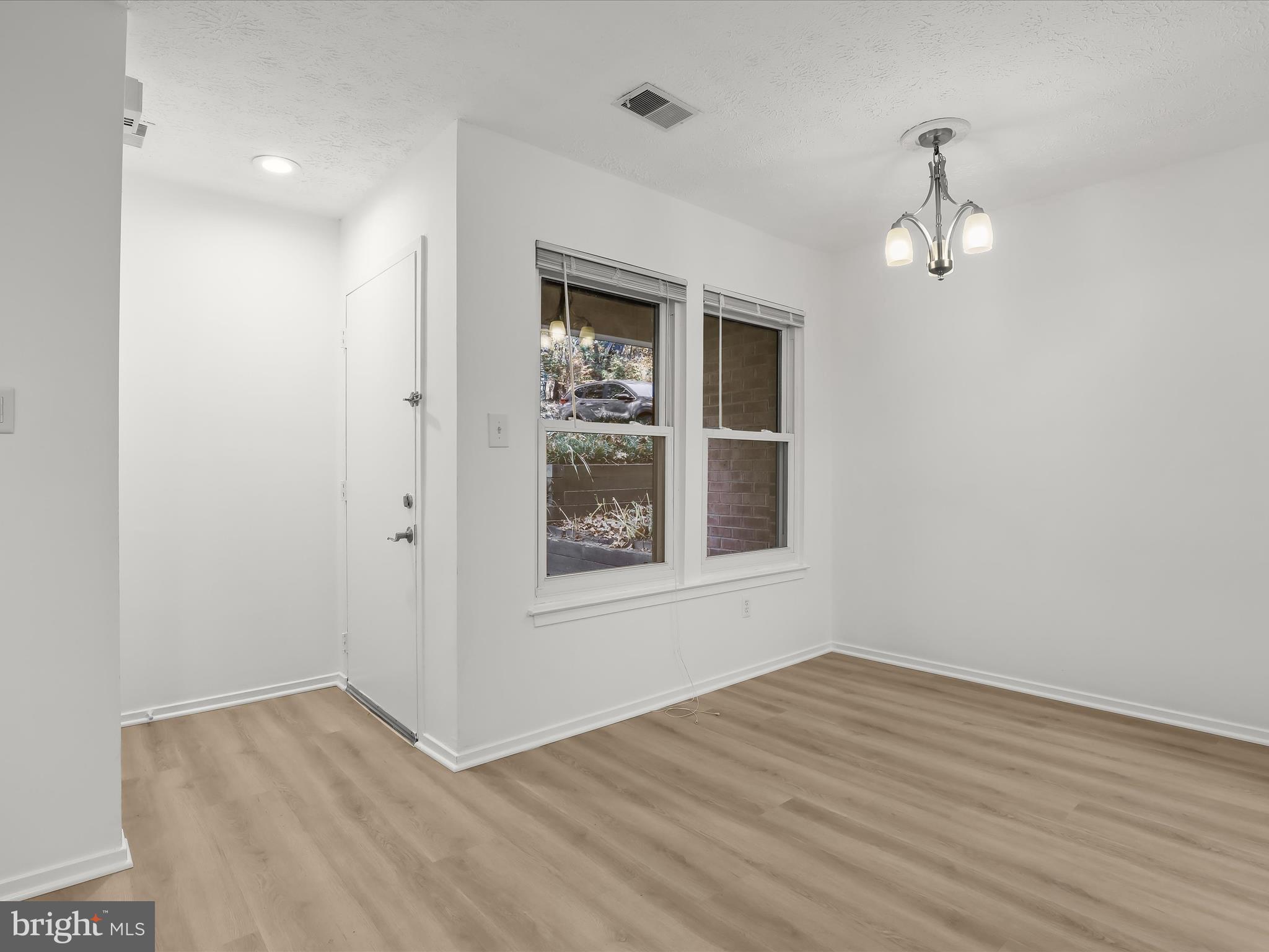 7517 Weather Worn Way, Unit A Columbia, MD 21046 - Photo 3 of 27 an empty room with wooden floor cabinet and windows