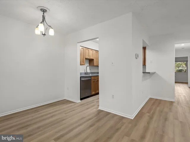 an empty room with wooden floor cabinet and windows