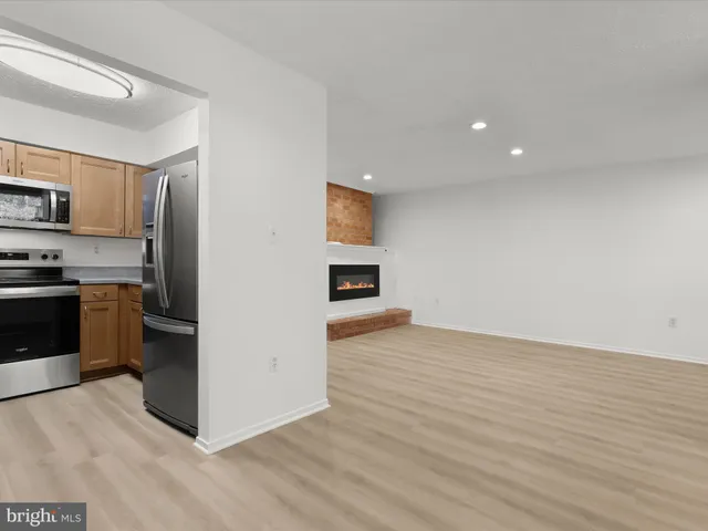 a view of a kitchen with wooden floor and a ceiling fan