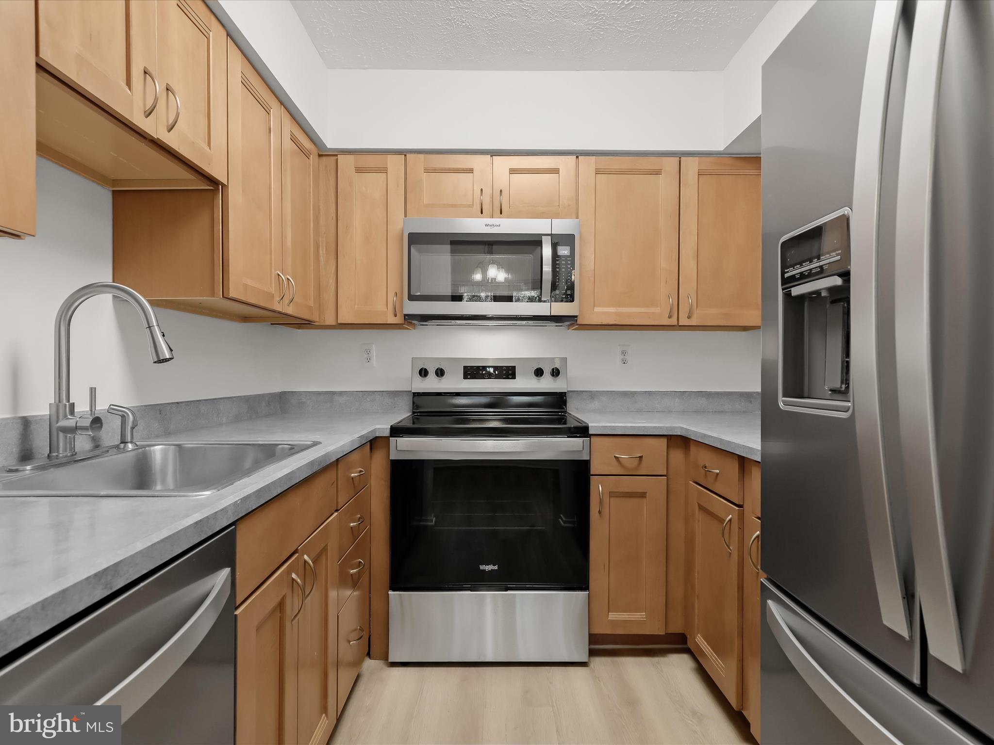 7517 Weather Worn Way, Unit A Columbia, MD 21046 - Photo 7 of 27 a kitchen with stainless steel appliances granite countertop a stove a sink and a refrigerator