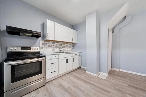 a kitchen with stainless steel appliances white cabinets and a stove