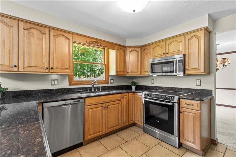 116 Foxglove Road Baden, PA 15005 - Photo 8 of 42 a kitchen with stainless steel appliances granite countertop a stove a sink and a microwave