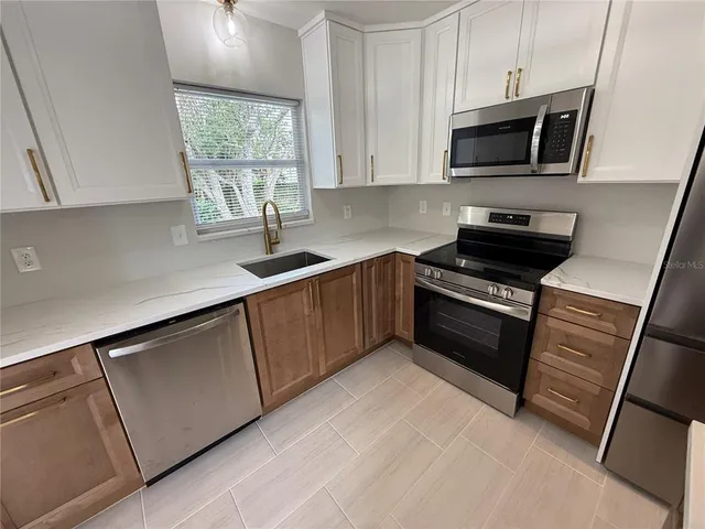 a kitchen with a sink and steel appliances