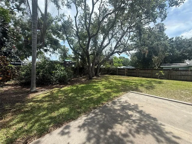a view of a yard with large trees