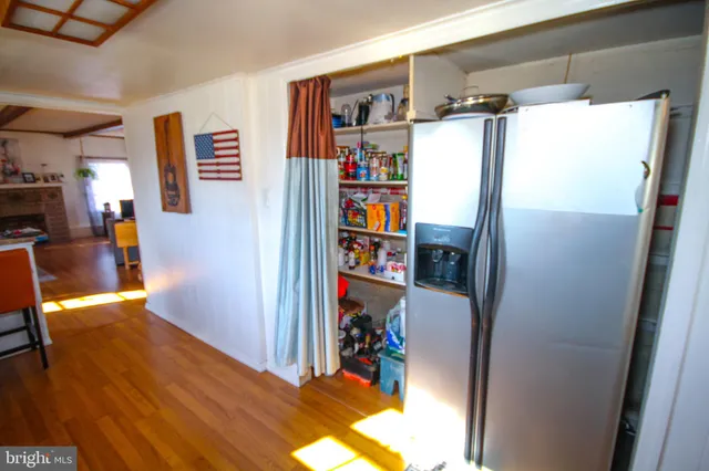 a view of a kitchen with fridge and wooden floor