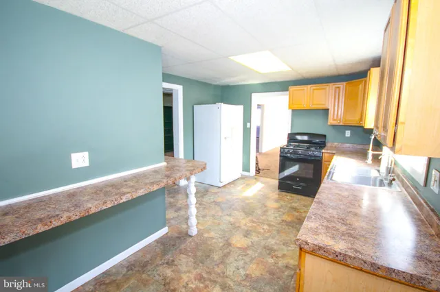 a kitchen with stainless steel appliances granite countertop sink stove top oven and cabinets