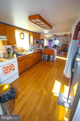 a large room with wooden floor pool table and chairs