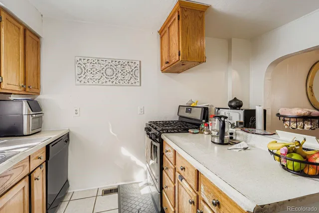a kitchen with stainless steel appliances granite countertop a sink a stove and a wooden cabinets