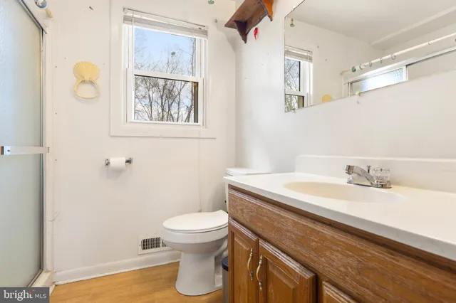 a bathroom with a granite countertop toilet sink and mirror