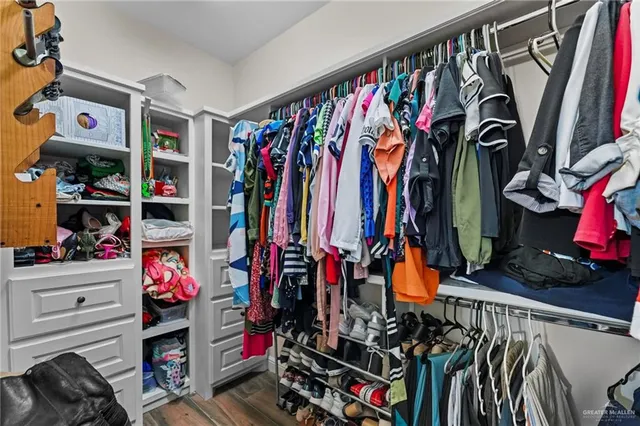 a view of walk in closet with clothes and shoes