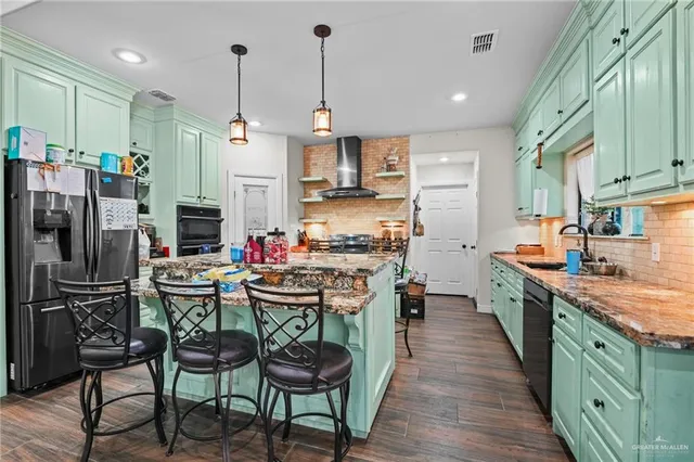 a kitchen with stainless steel appliances a dining table chairs stove and refrigerator