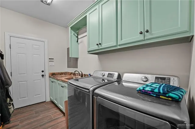 a utility room with stainless steel appliances wooden floor and a window