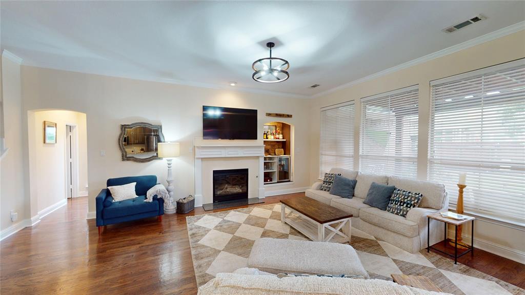 1747 Ivy Lane Carrollton, TX 75007 - Photo 2 of 21 a living room with furniture a fireplace and a flat screen tv