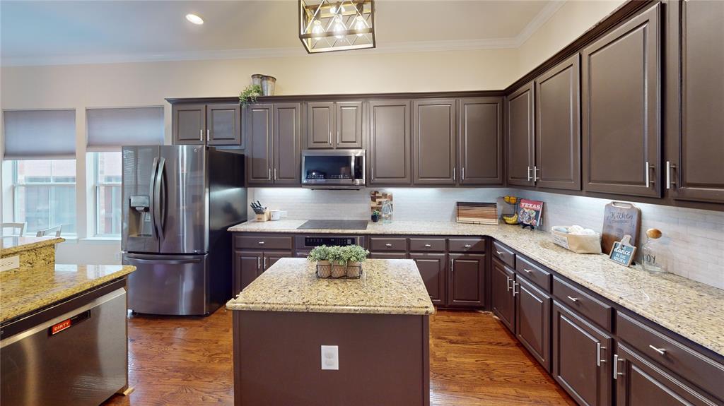 1747 Ivy Lane Carrollton, TX 75007 - Photo 6 of 21 a kitchen with kitchen island granite countertop stainless steel appliances and wooden cabinets