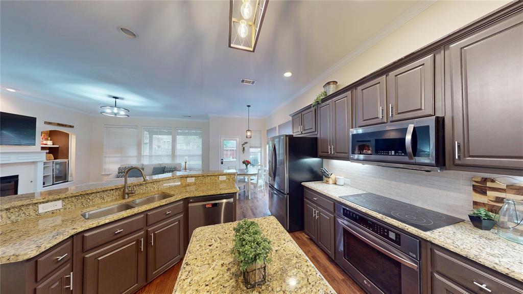 1747 Ivy Lane Carrollton, TX 75007 - Photo 8 of 21 a kitchen with stainless steel appliances granite countertop a sink stove microwave and refrigerator