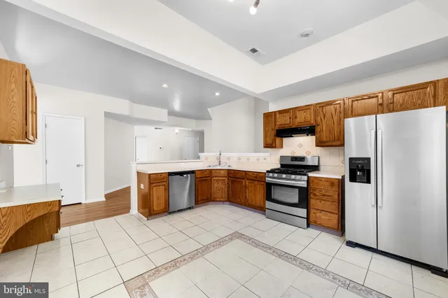 a kitchen with stainless steel appliances a refrigerator sink and microwave