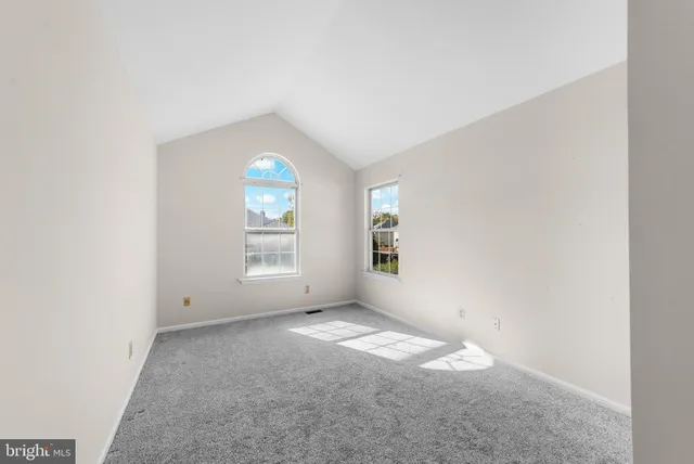 an empty room with windows and mirror