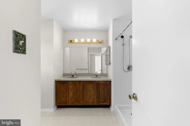 a bathroom with a granite countertop sink a mirror and a shower