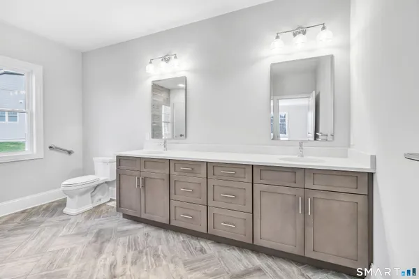 a spacious bathroom with a double vanity sink mirror and toilet