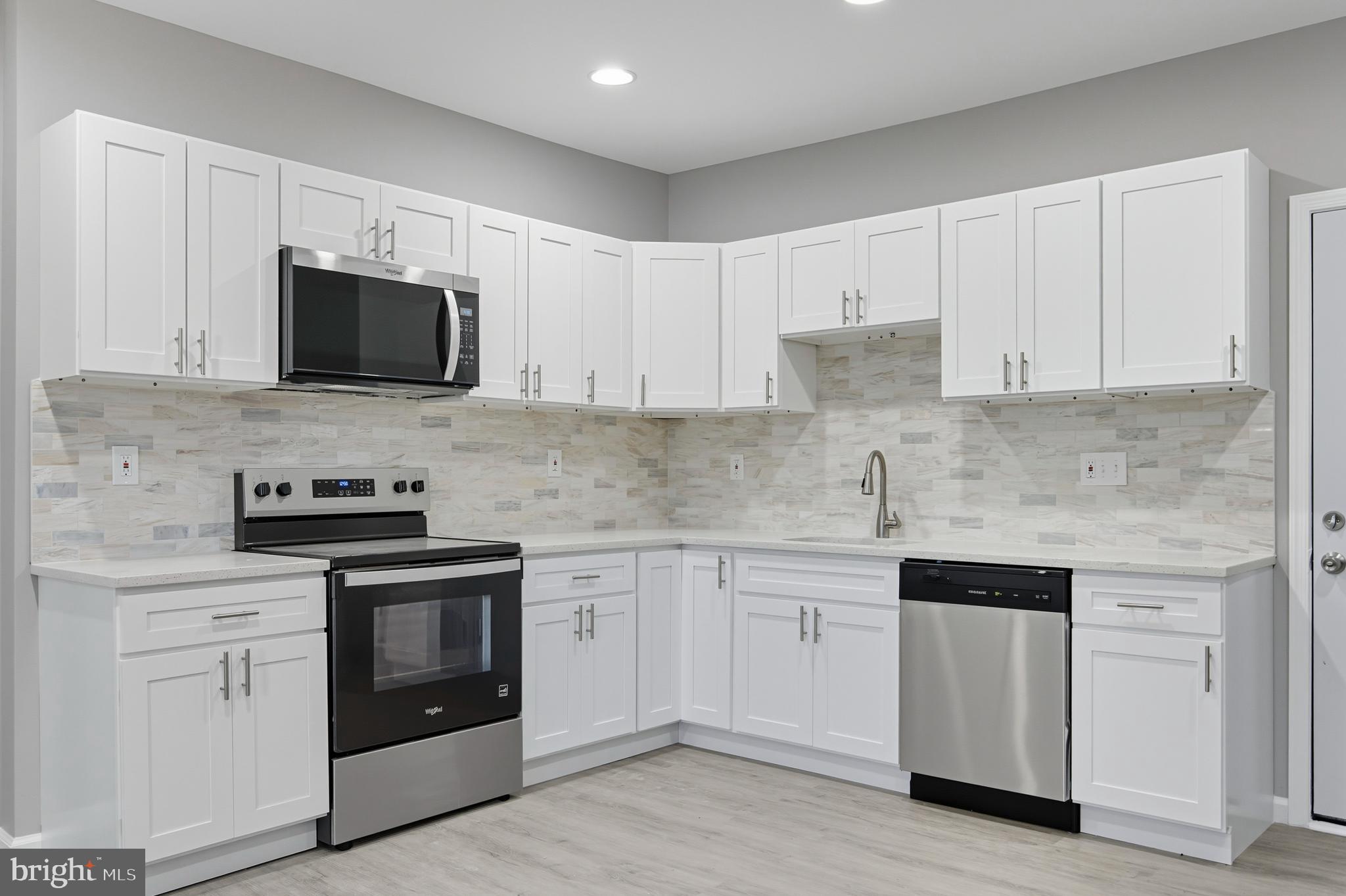 809 East Pontiac Avenue Baltimore, MD 21225 - Photo 10 of 36 a kitchen with white cabinets and stainless steel appliances