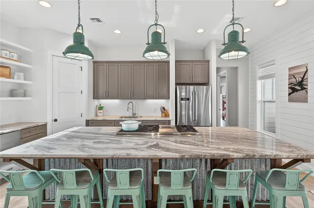 a kitchen island with stainless steel appliances granite countertop wooden floor