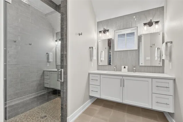 a bathroom with a double vanity sink a mirror and a shower