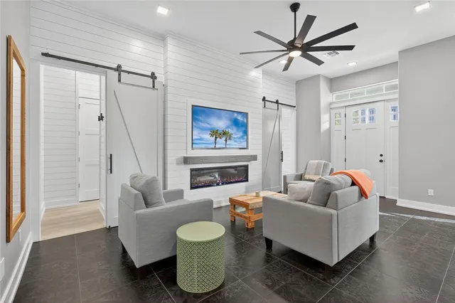a living room with furniture a fireplace and a ceiling fan