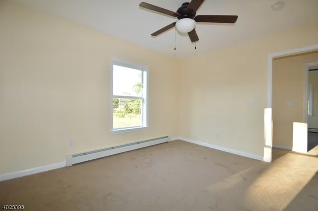 an empty room with a window and a fan