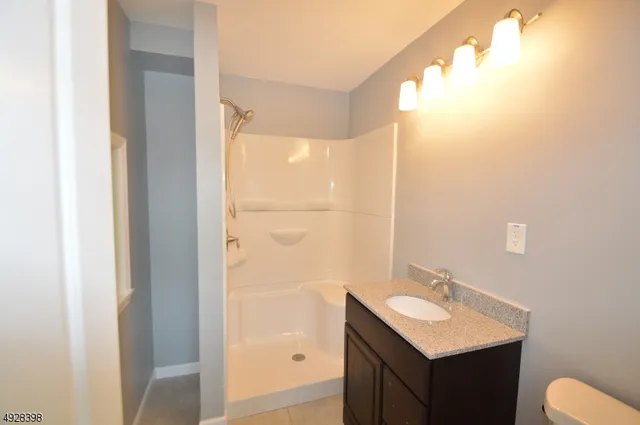 a bathroom with a sink mirror and shower