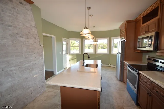 a kitchen with stainless steel appliances granite countertop a sink a stove and a wooden floors