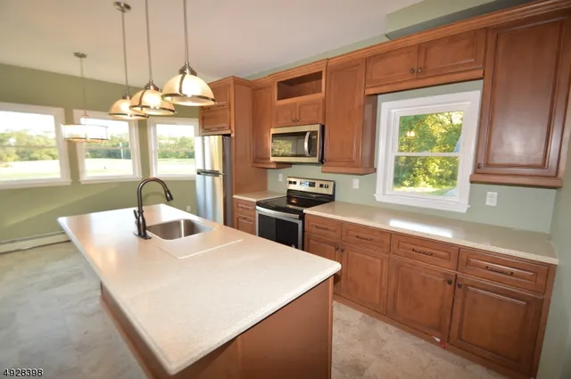 a kitchen with stainless steel appliances granite countertop a sink a stove and a refrigerator