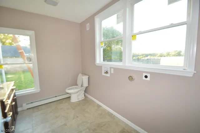 a bathroom with a toilet a sink and a window