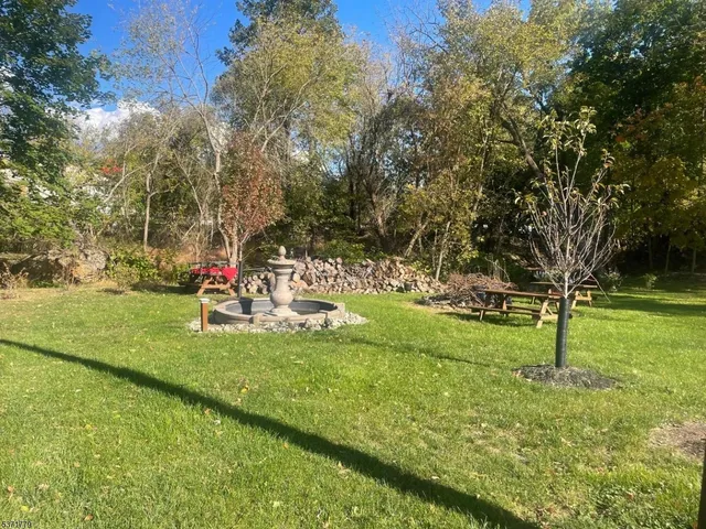 a front view of a house with garden and sitting area