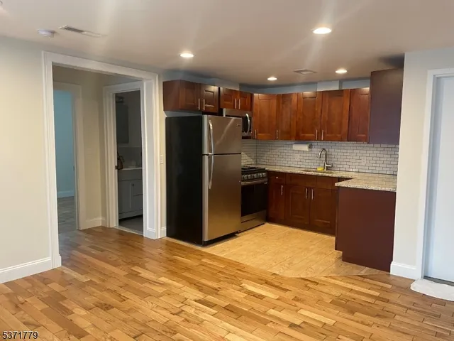 a kitchen with granite countertop a refrigerator and a sink