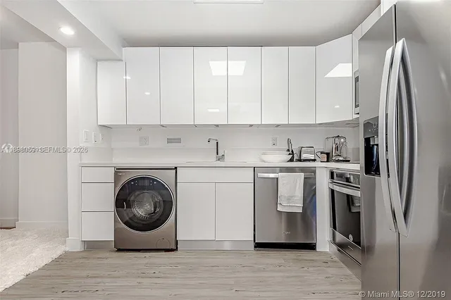 a kitchen with white cabinets and stainless steel appliances