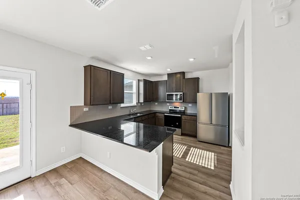 a kitchen with stainless steel appliances granite countertop a refrigerator and a stove