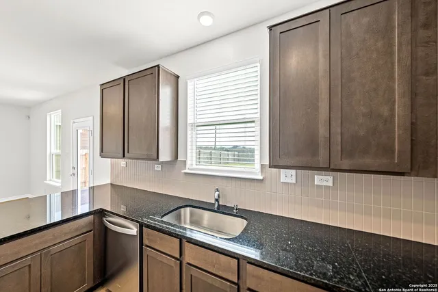 a kitchen with granite countertop a sink and a window