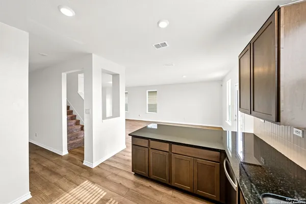 a kitchen with granite countertop a refrigerator and a sink