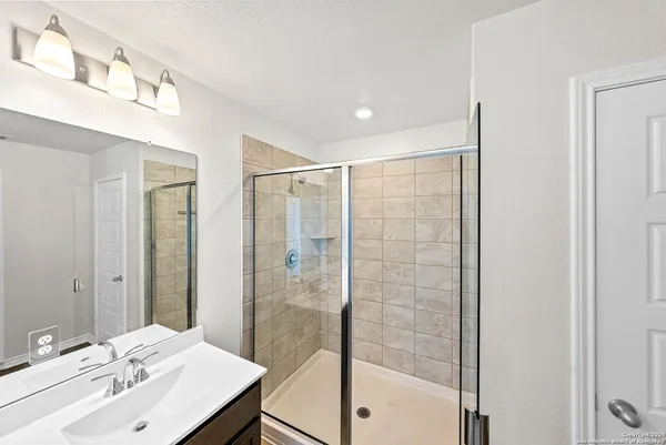 a bathroom with a shower sink and mirror